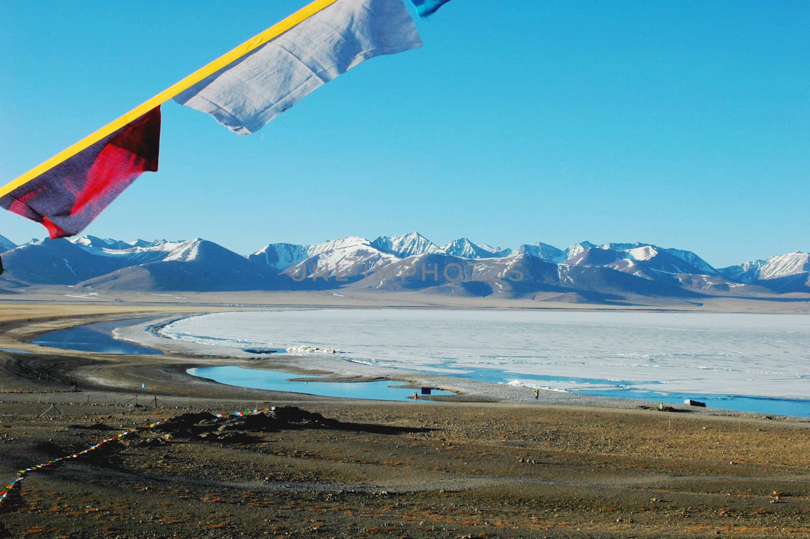 Landscape of snow mountains and frozen lake in the highlands of Tibet in the early spring