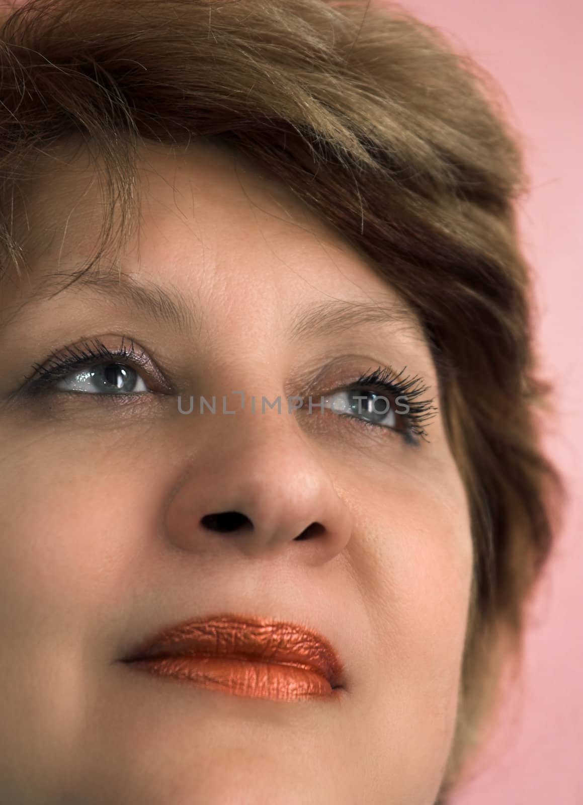 Portrait of the middle-aged woman on a pink background