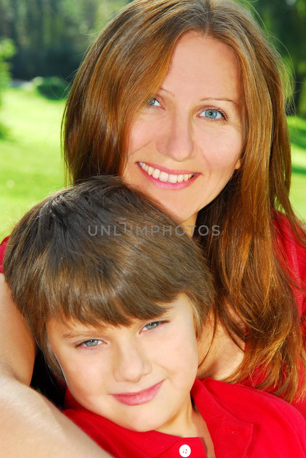 Portrait of smiling mother and son in summer park