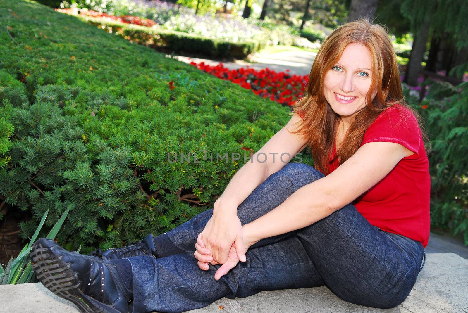 Smiling attractive mature woman relaxing in summer park