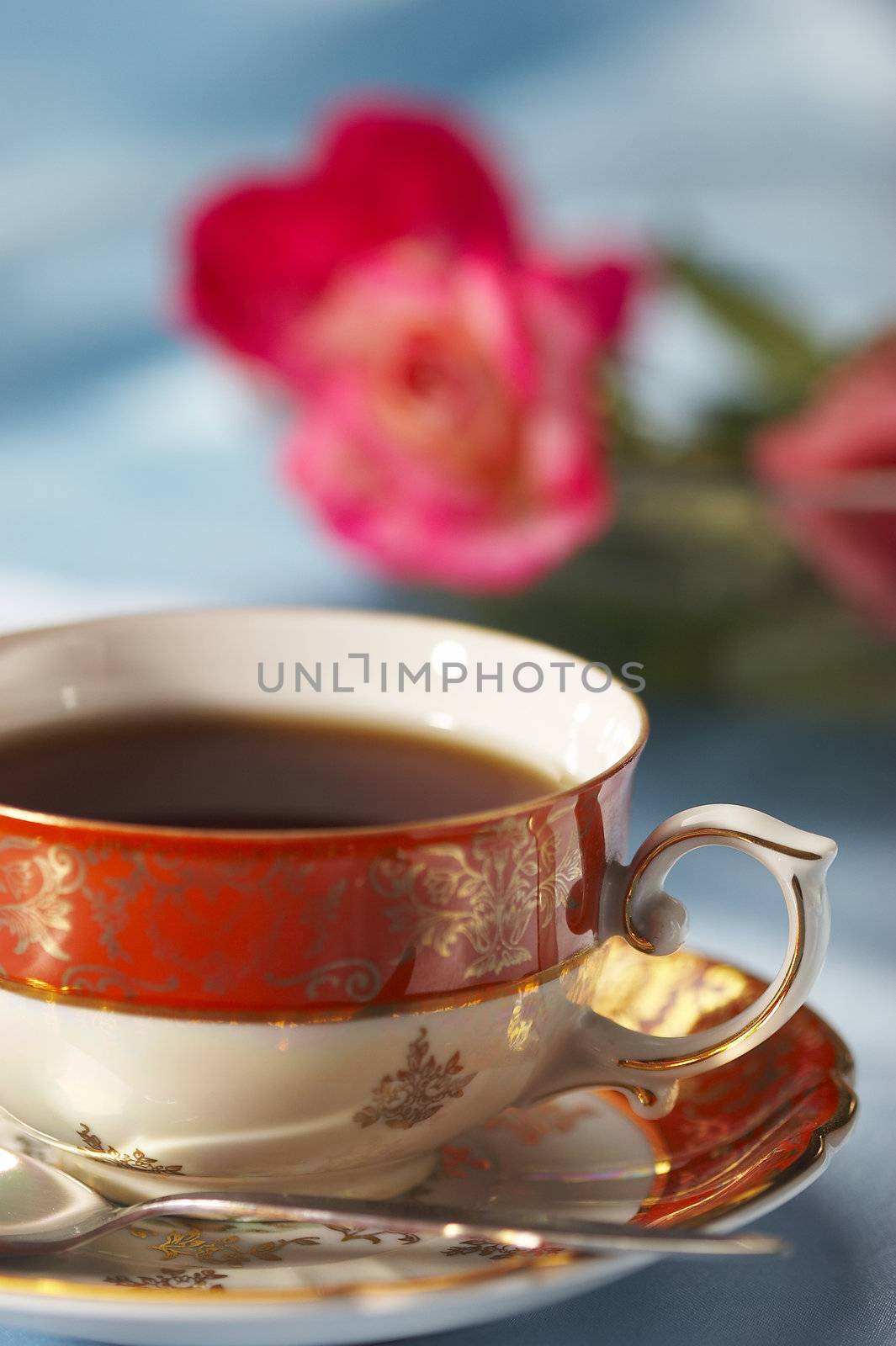 cup of tea with flower over blue background