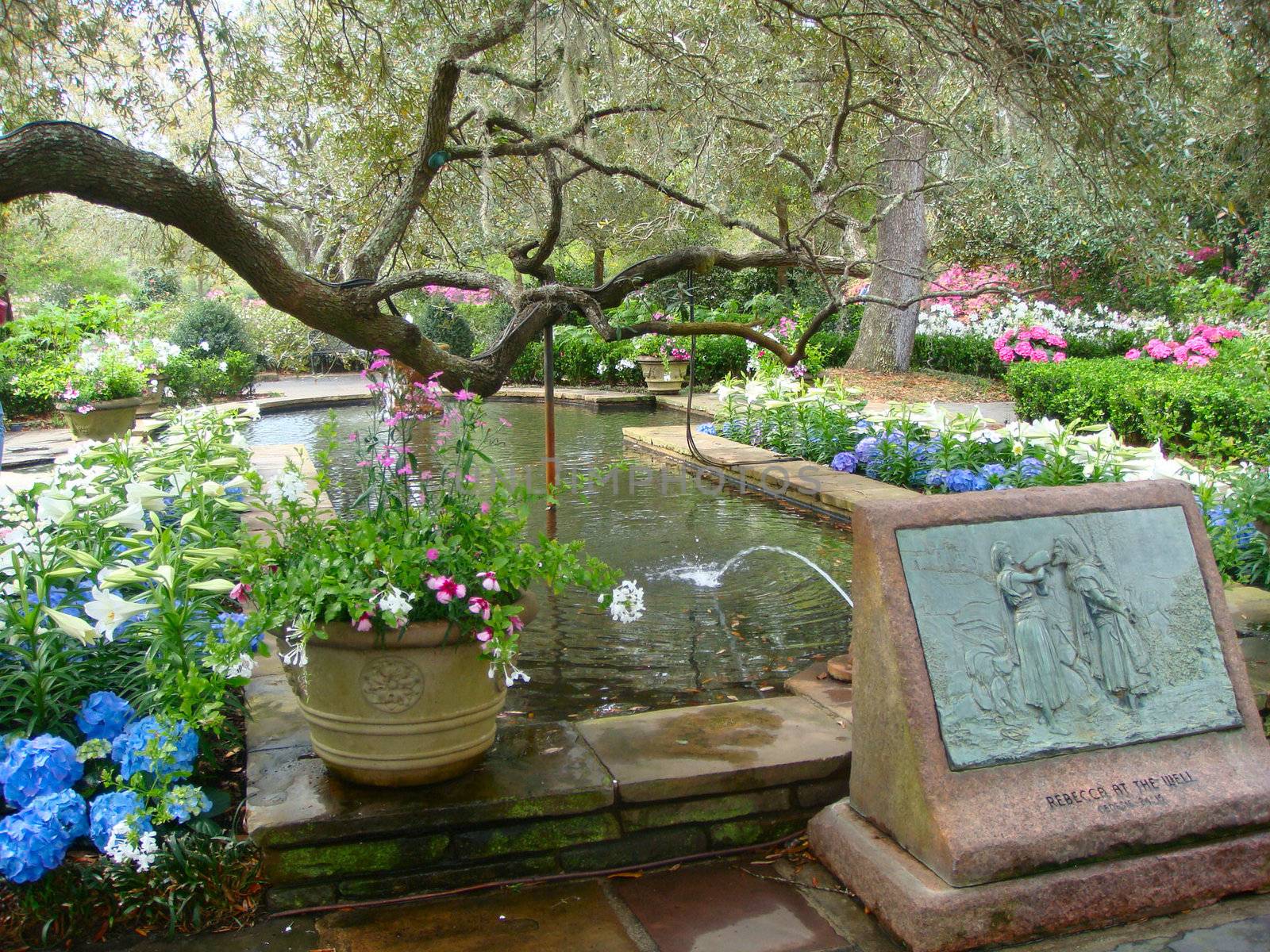 A fountain runs into a pond with a beautiful scenery at the Bellingrath Gardens, Alabama