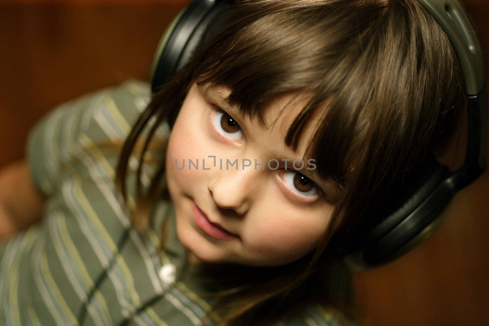 Adorable five year old wearing headphones.
