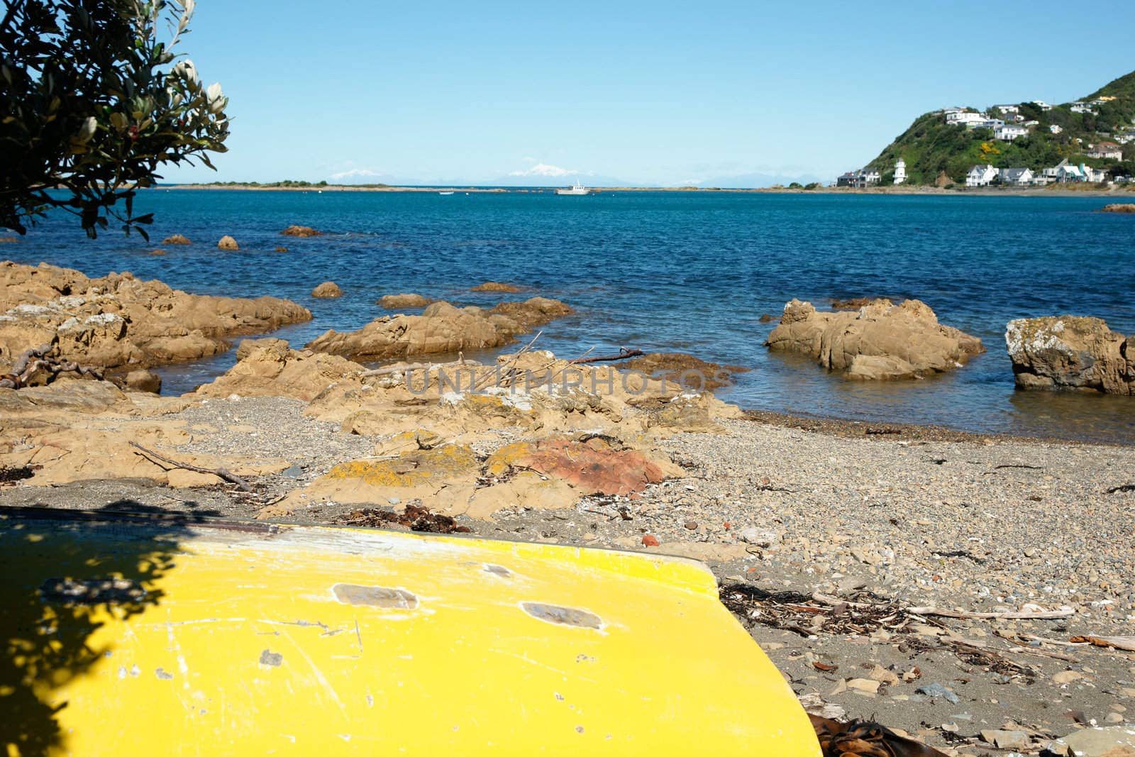 Beach scene with upturned yellow boat at Island Bay, Wellington, New Zealand.
