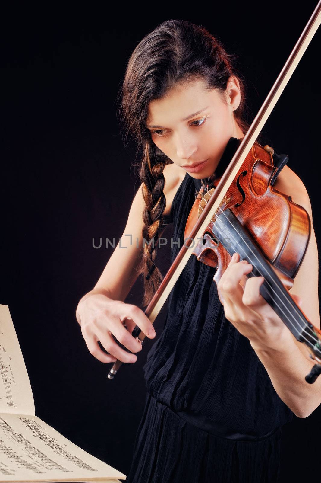 A young woman playing a violin on notes