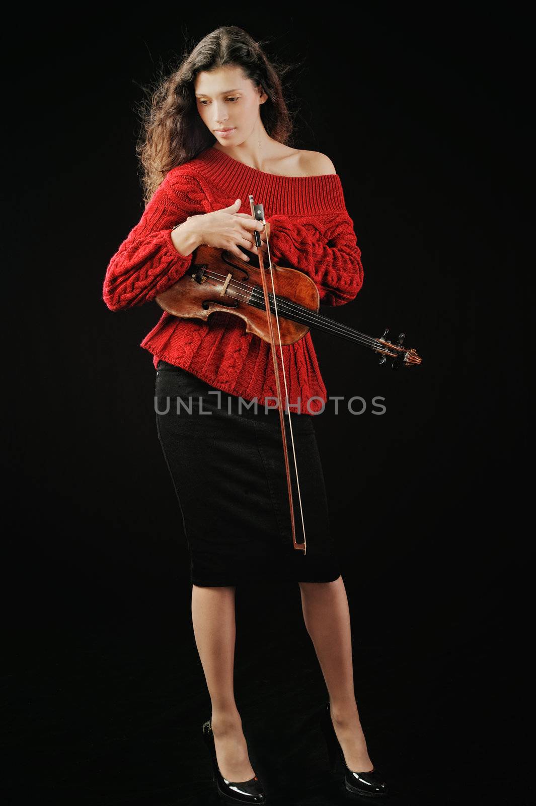 Young woman holding a violin. Isolated on the black background