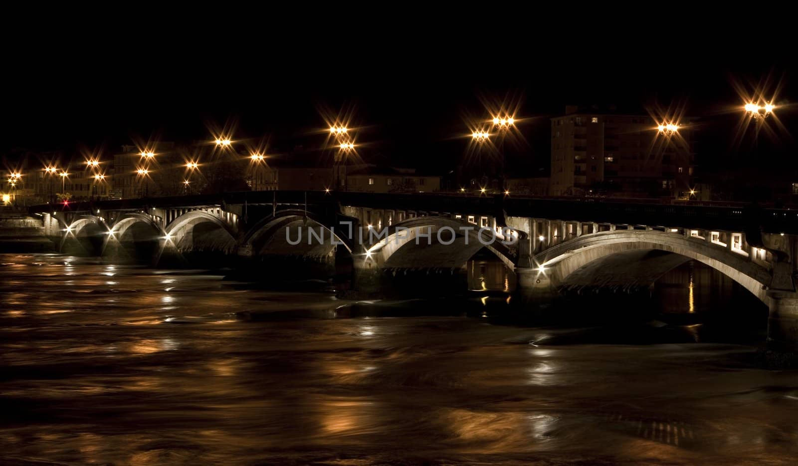 Stone bridge through a river during the night