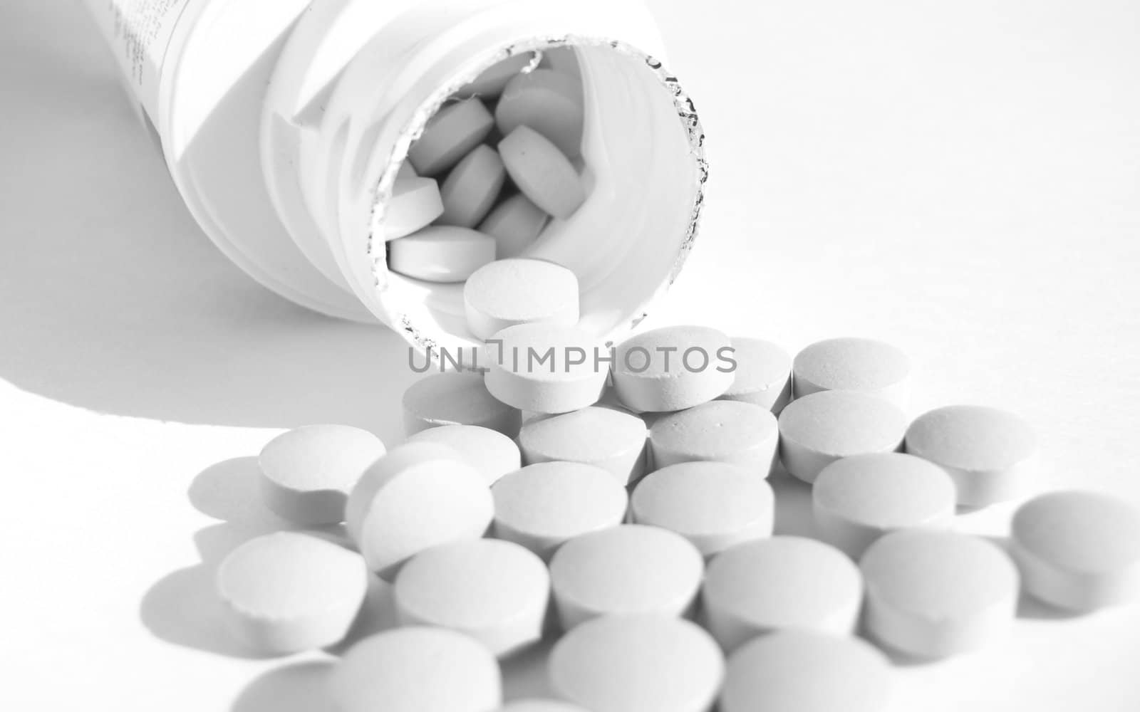 Bottle and tablets in white background