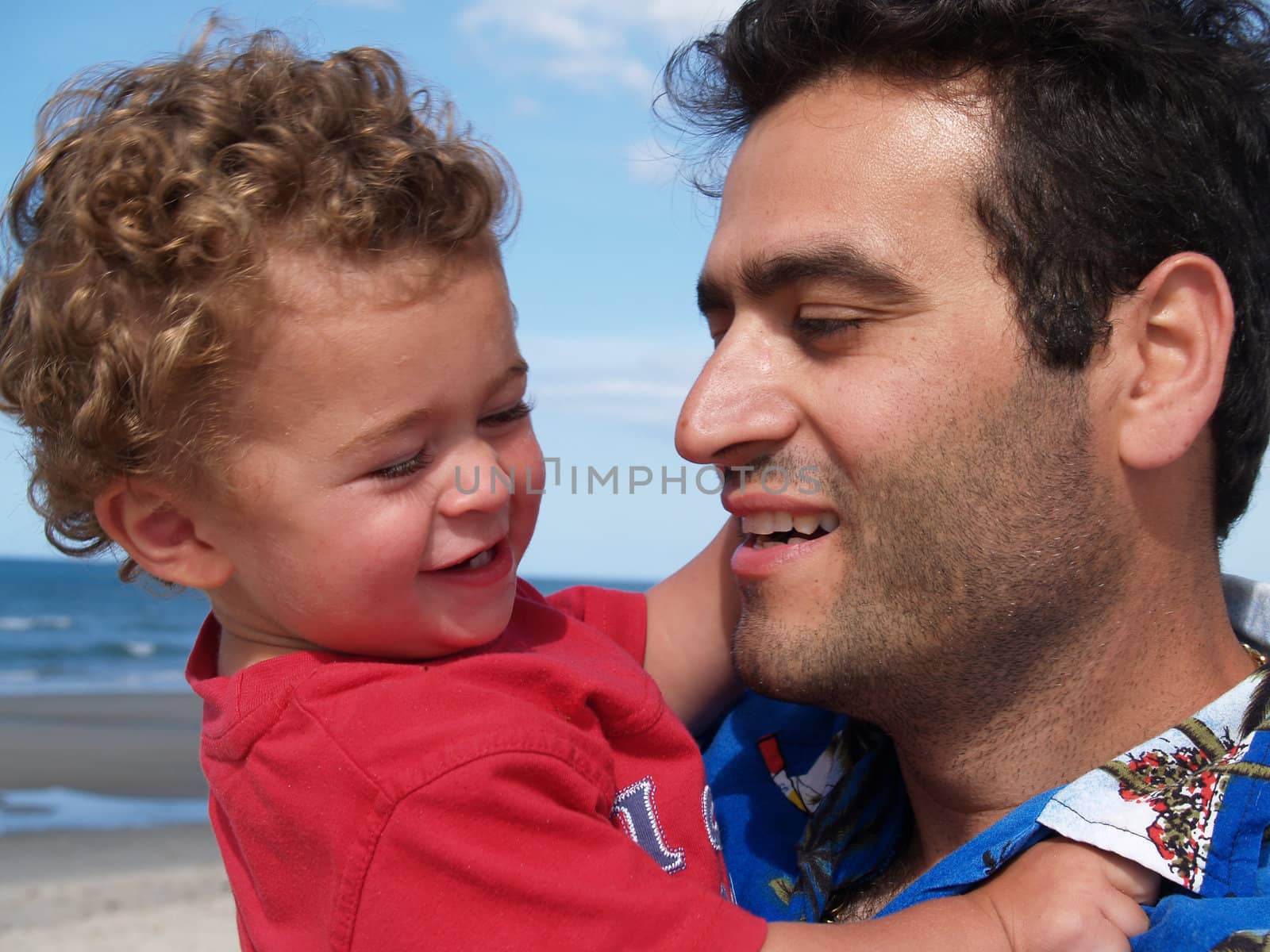 Father and son at beach, close up. by brians101