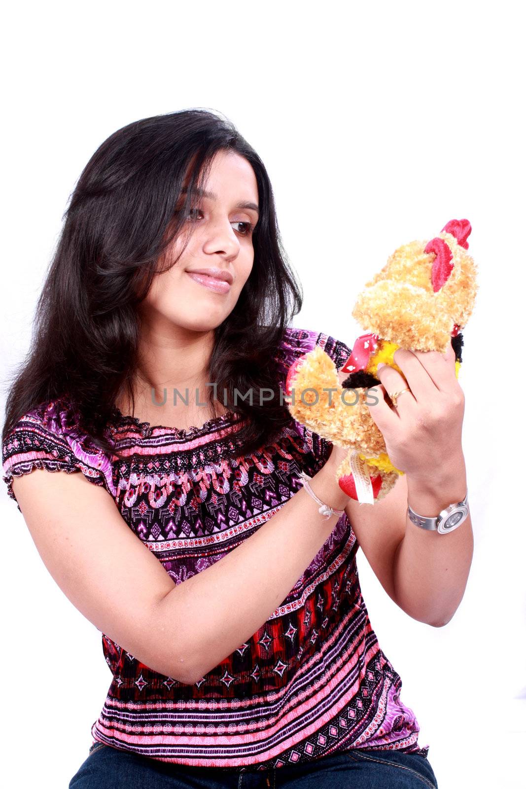 A cute Indian girl with her teddy bear, isolated on white background.