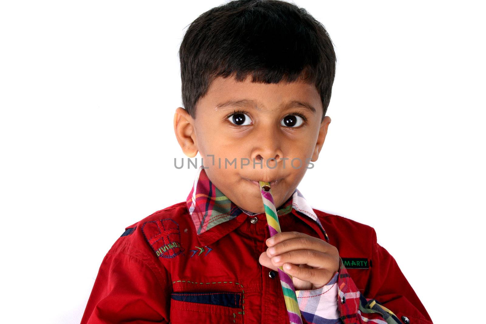 A cute Indian kid playing a toy flute, isolated on white studio background.