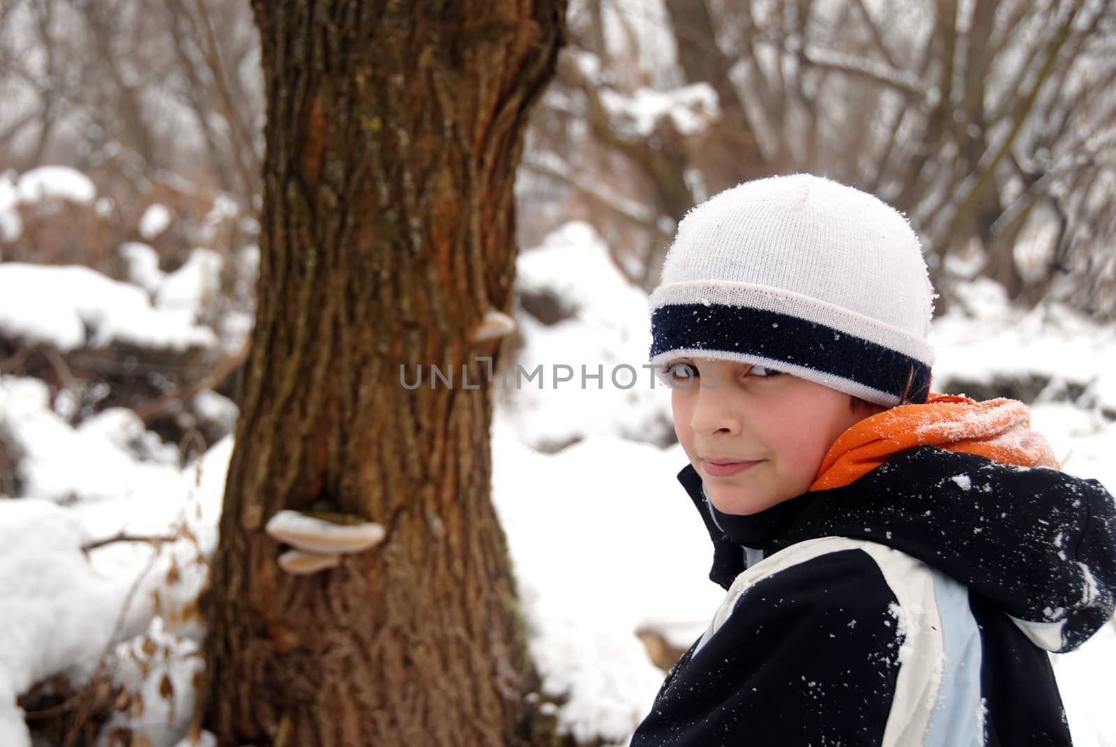 teenage smiling caucasian boy outdoor over winter snowy background