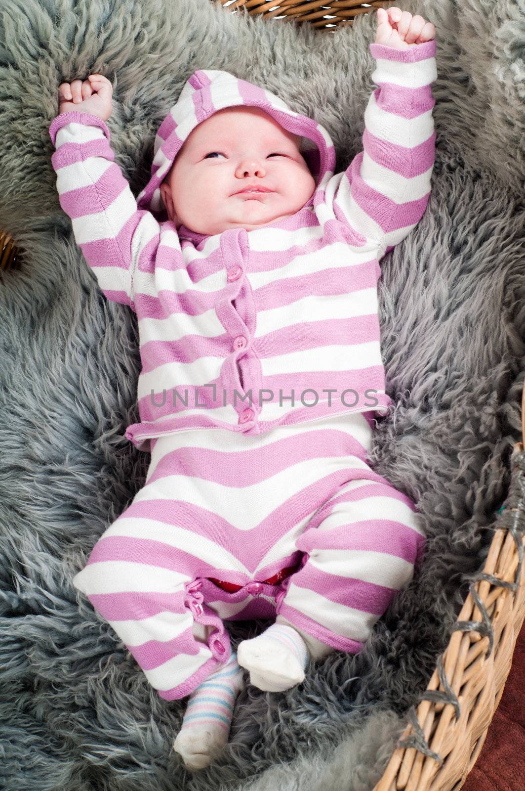 Shot of little cute baby in stripped clothes