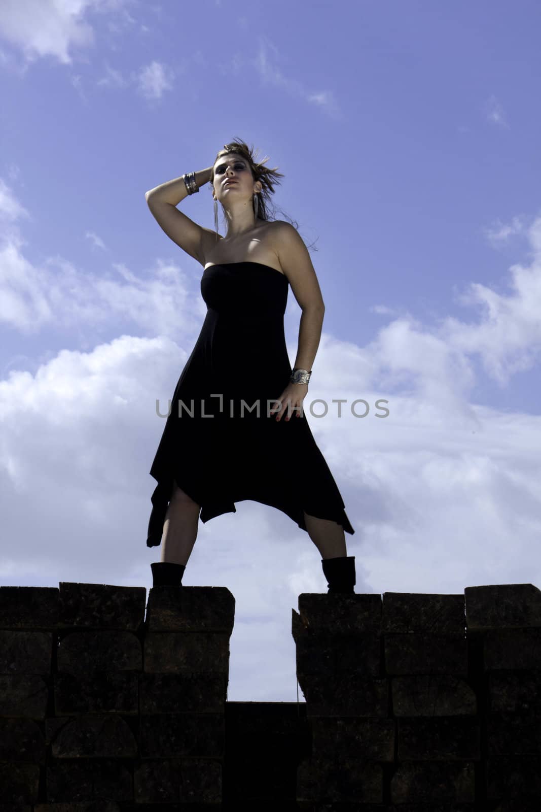 View of a beautiful woman with black dresson a fashion pose.