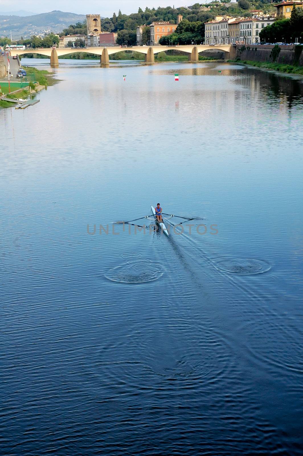 Man rowing a sports boat at the arno river