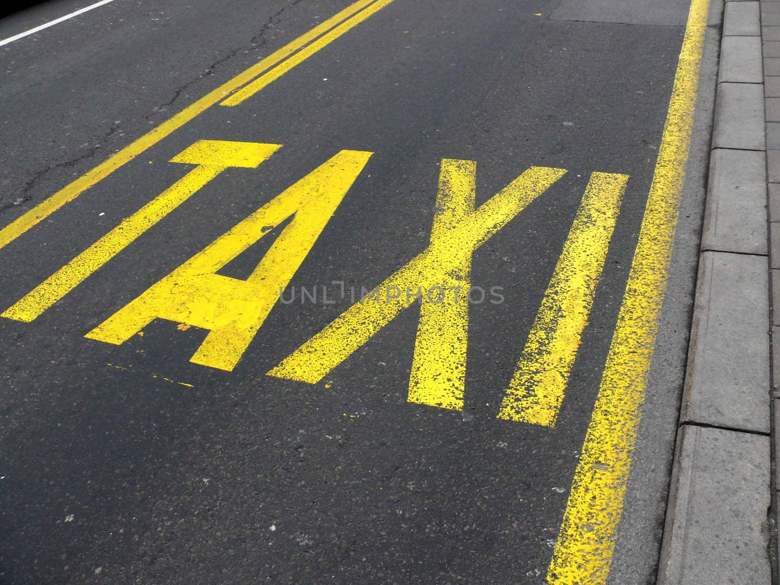 Yellow road sign on asphalt - Taxi. Belgrade. Serbia by Stoyanov