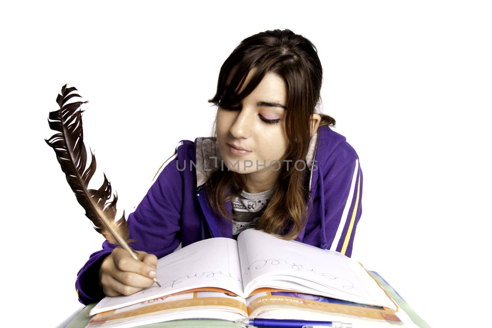 View of a teenager school girl writing on the book with a feather pen.
