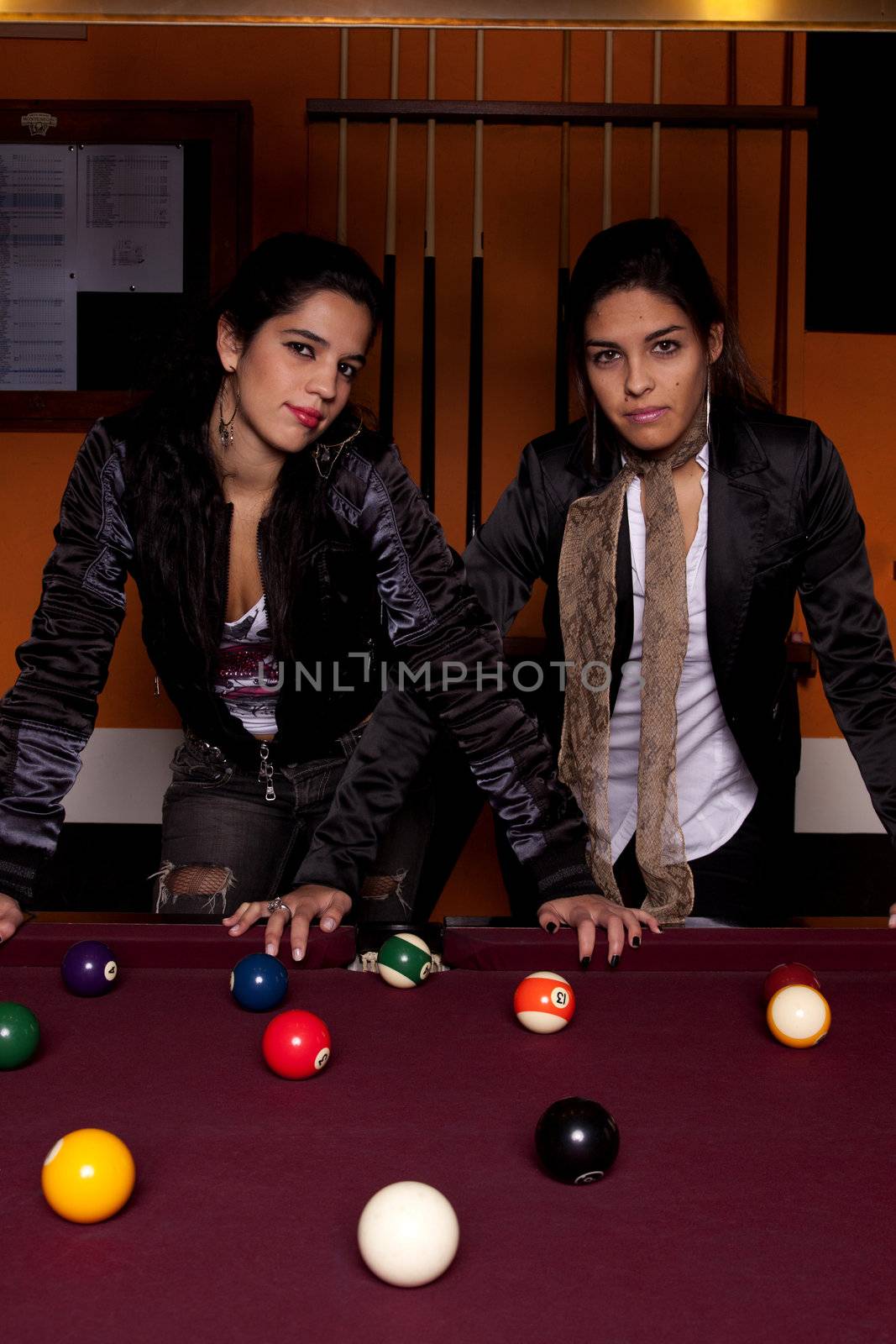 Detail view of two young girls next to a snooker table.