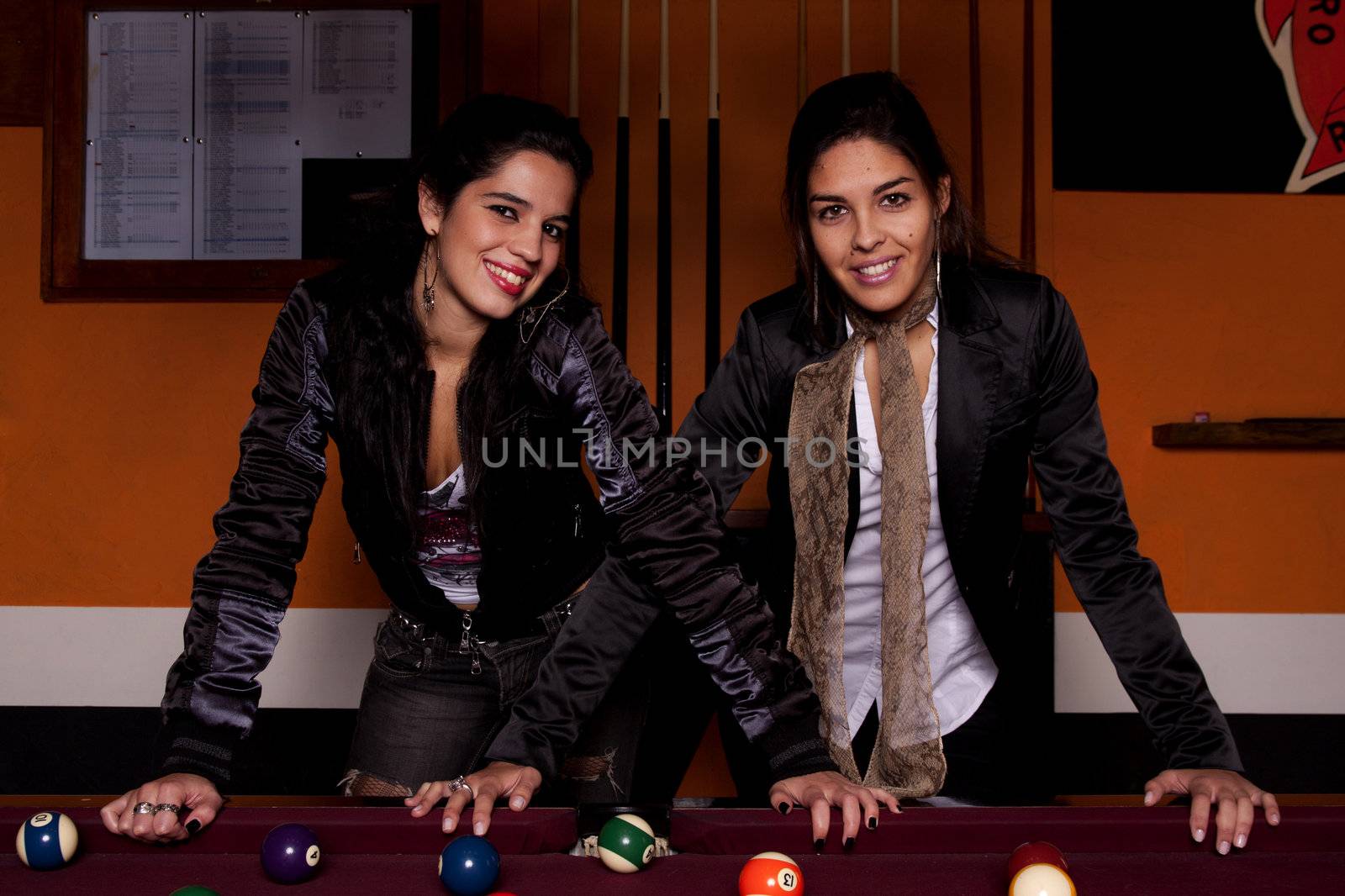 Detail view of two young girls next to a snooker table.