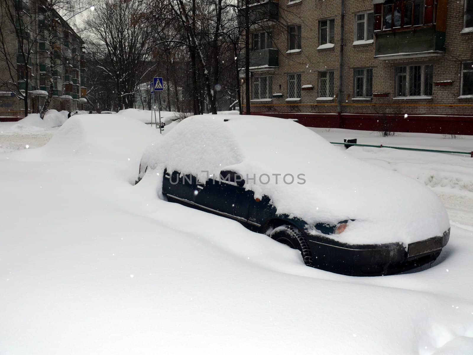 Car in snowdrift after snowfall in Moscow by Stoyanov