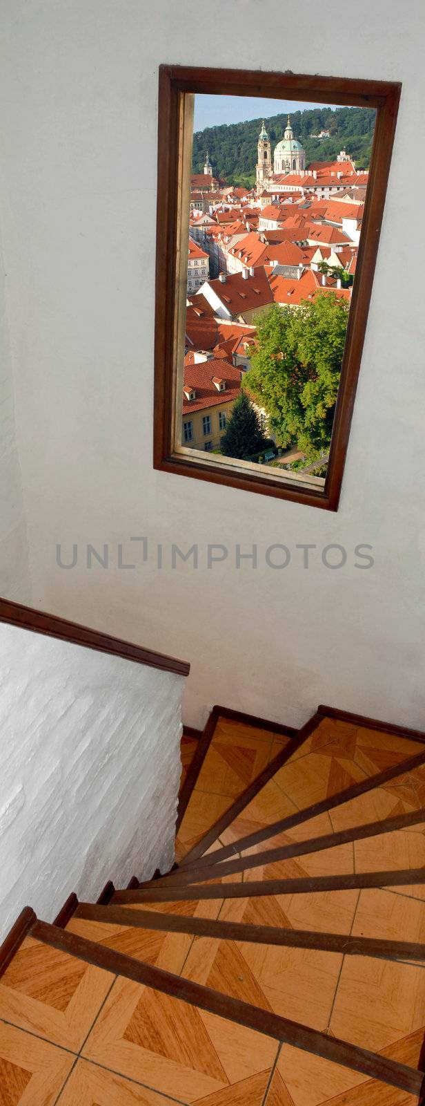 Staircase with window with view to Prague city roofs