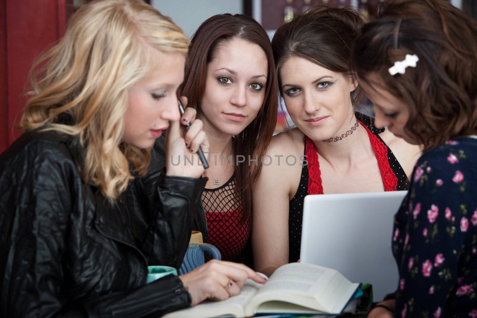 Four attractive girls busy with a school project