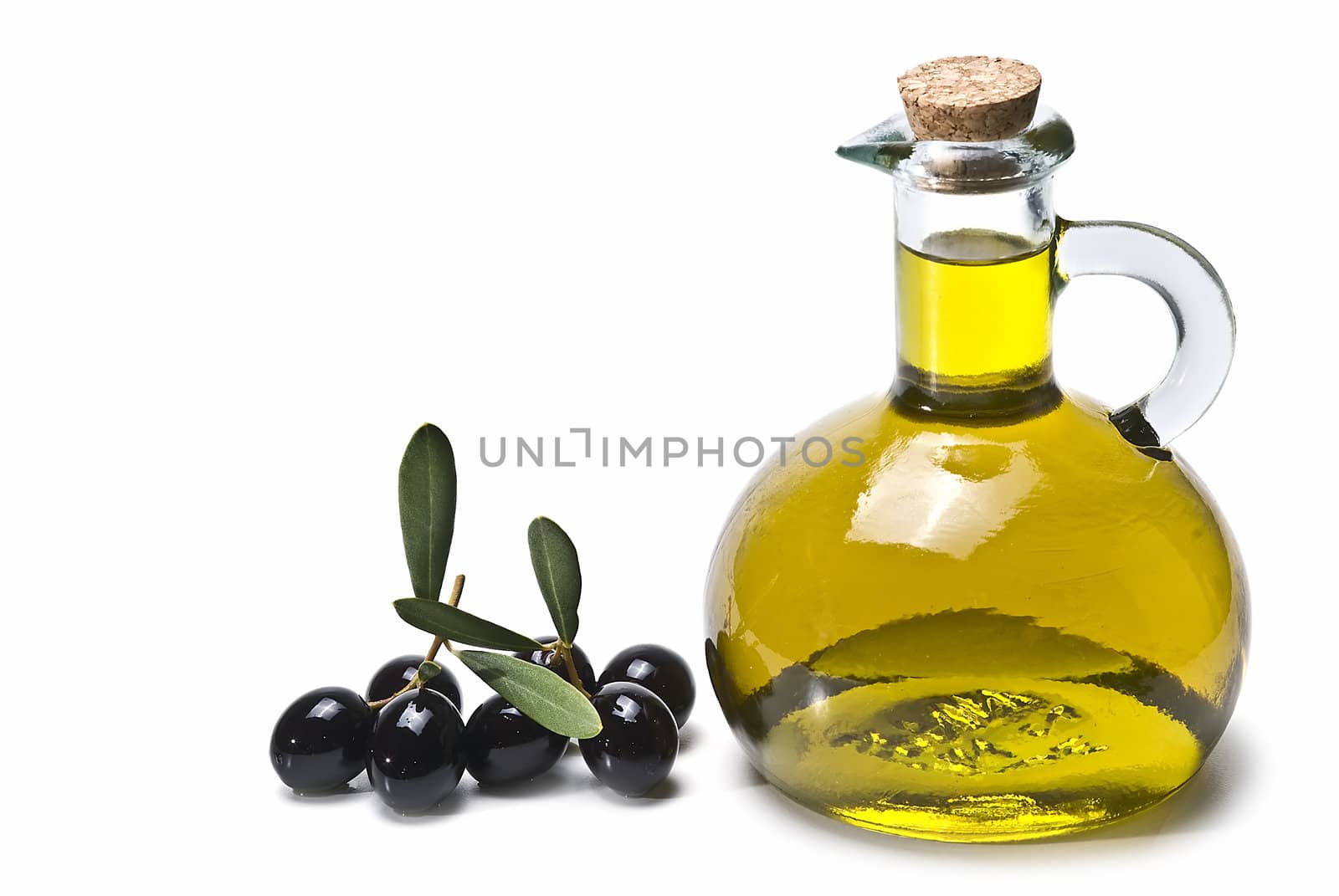 Some olives and olive oil isolated on a white background.