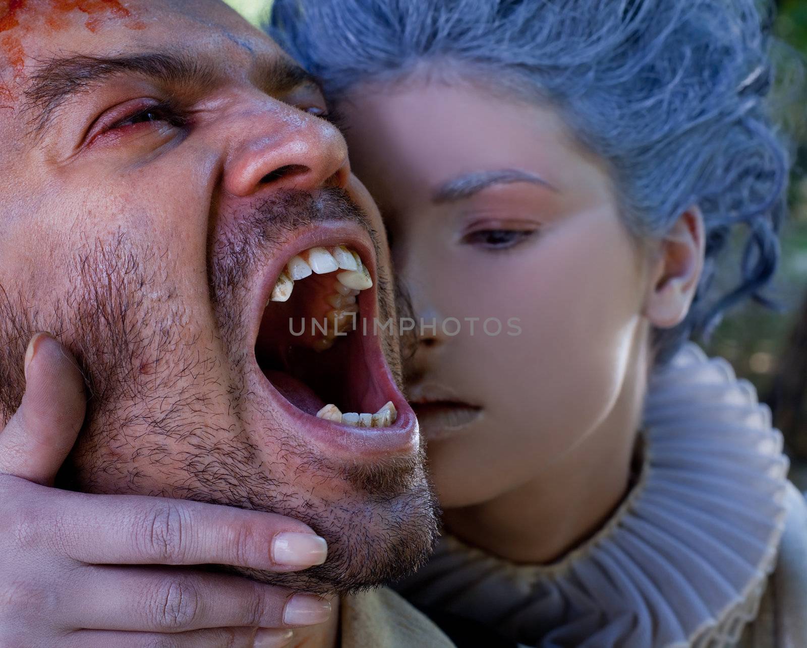 Close-up of medieval woman embracing wounded male vampire