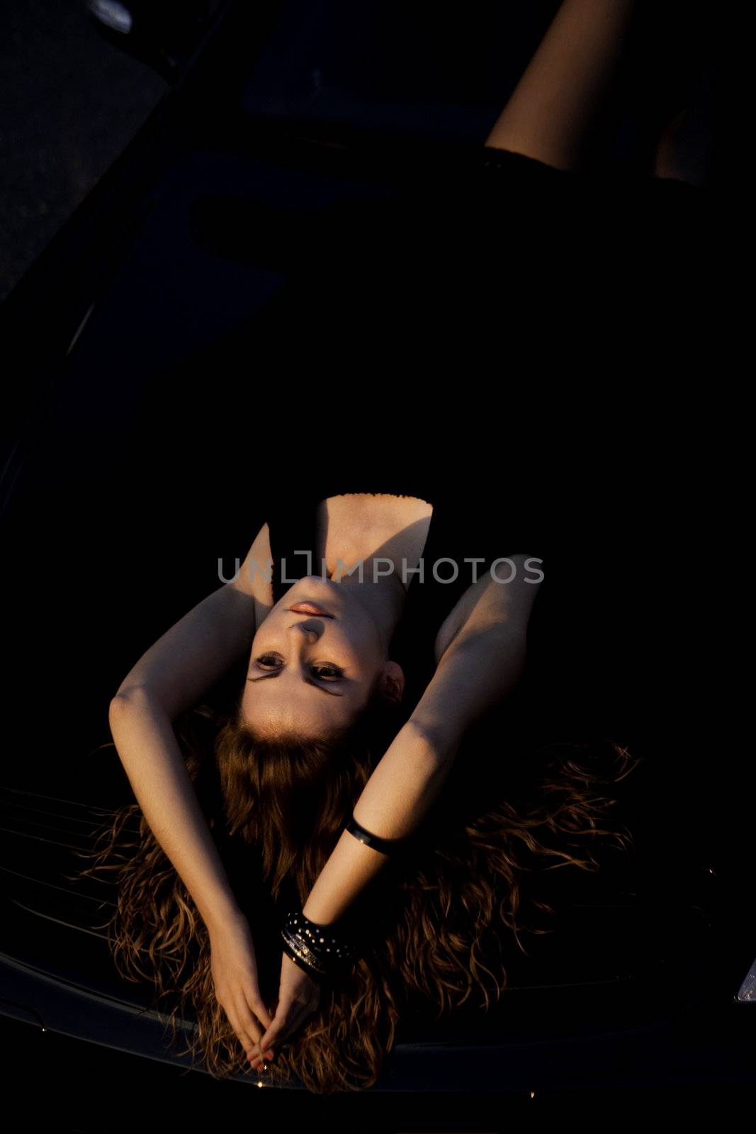 view of a beautiful woman on top of a sports car.