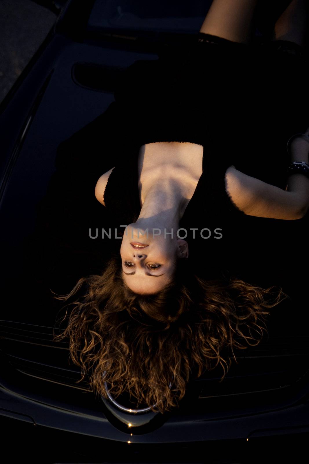 view of a beautiful woman on top of a sports car.