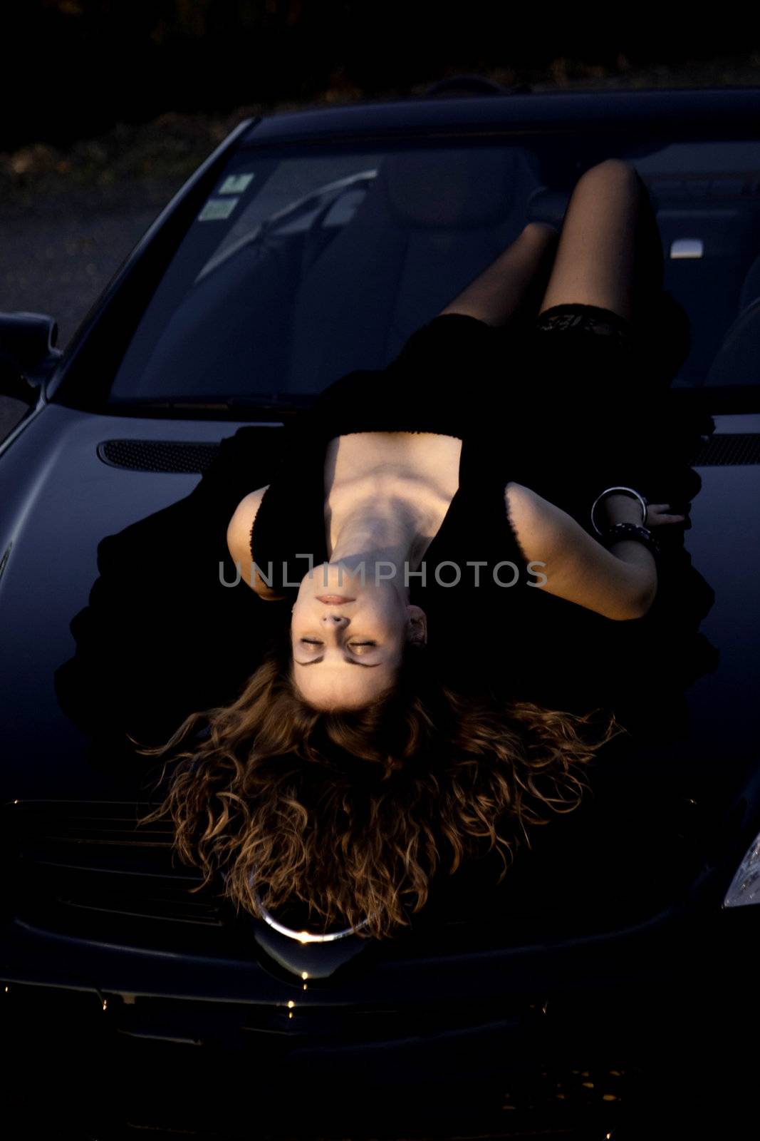view of a beautiful woman on top of a sports car.