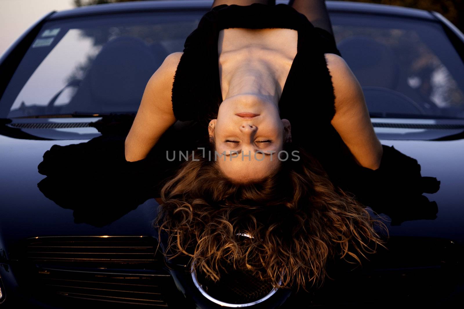 view of a beautiful woman on top of a sports car.