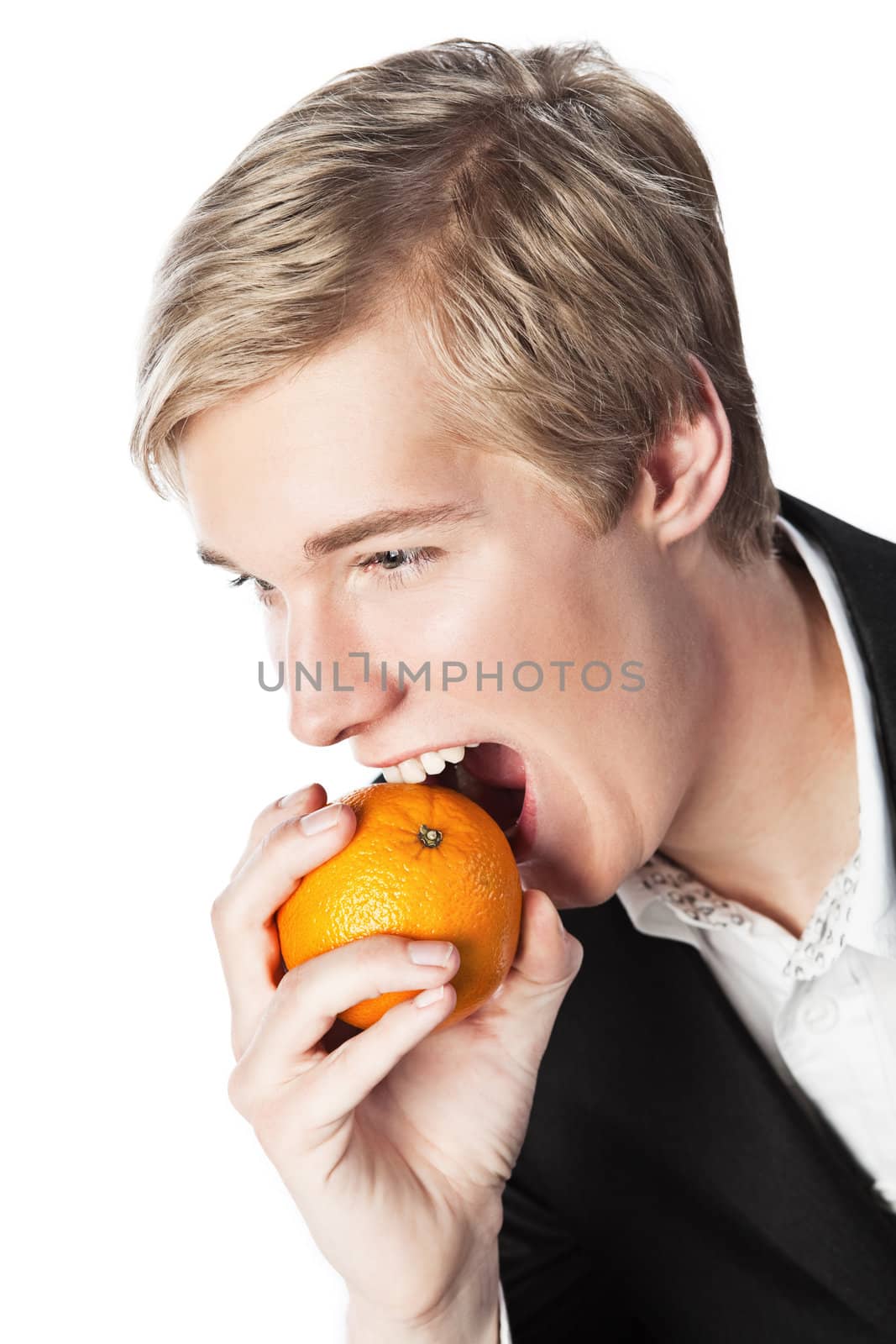 Smiling young handsome blond man biting an orange