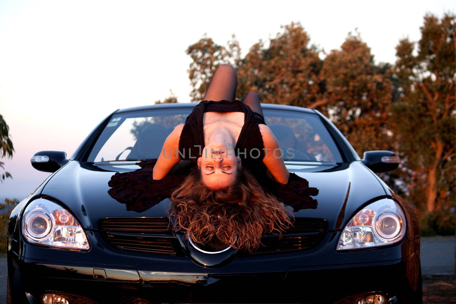 view of a beautiful woman on top of a sports car.