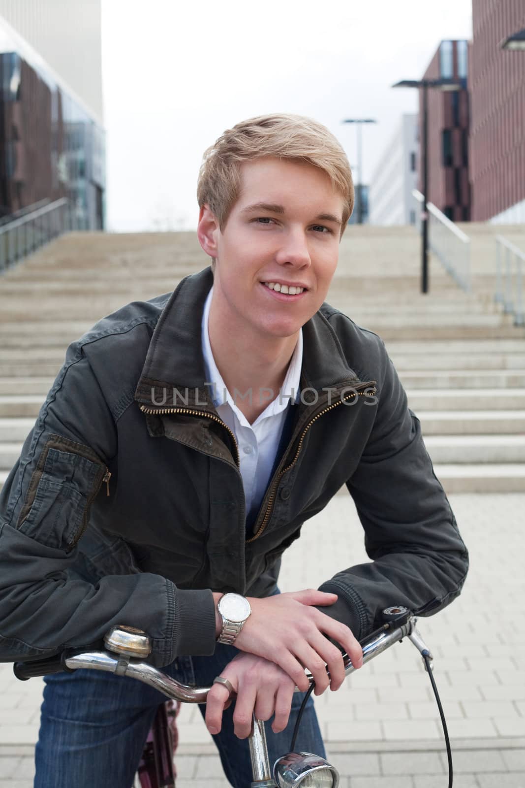 Young blond handsome guy standing with bicycle