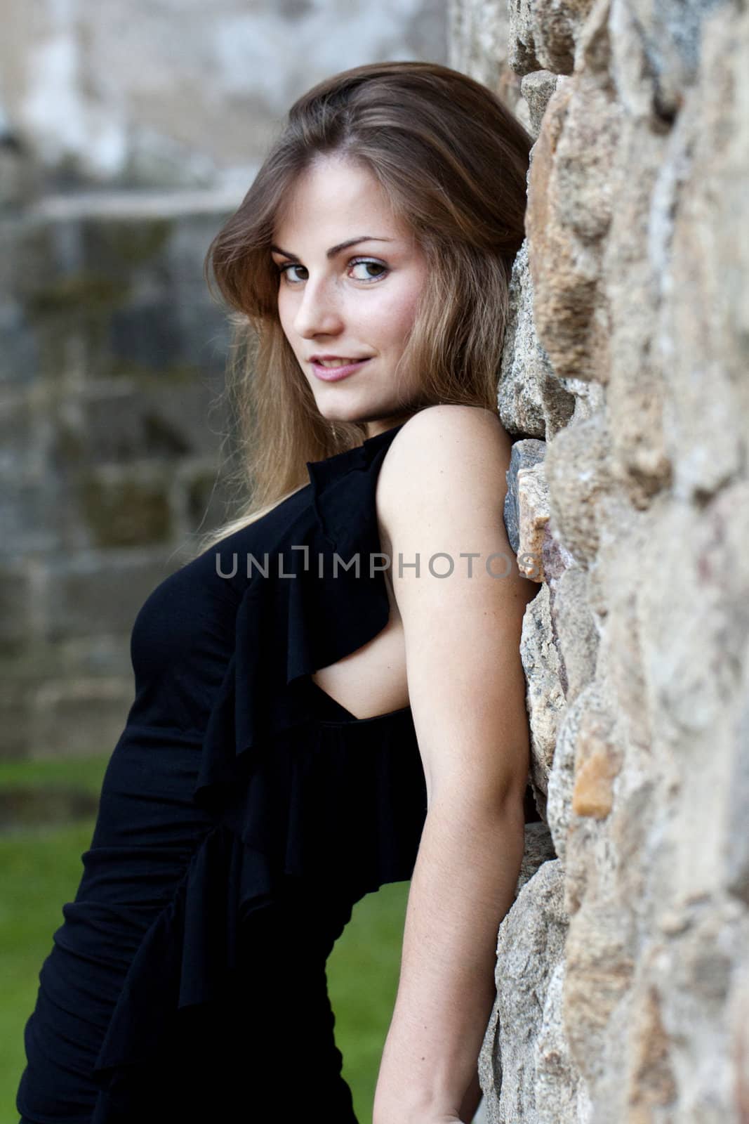 View of a beautiful girl on a black dress on a park.