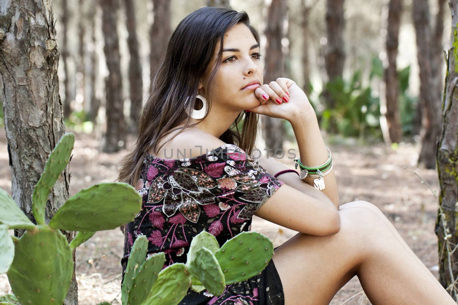 Beautiful girl with floral dress posing on a forest.