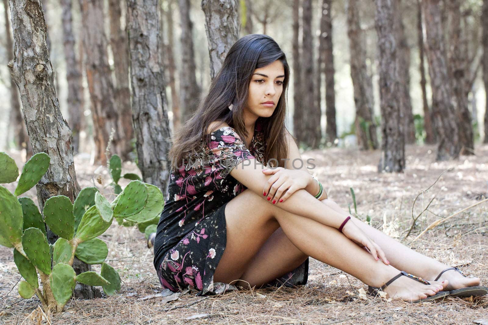 Beautiful girl with floral dress posing on a forest.