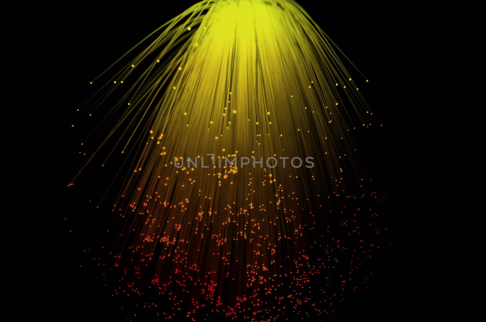 Yello and red coloured fibre optic light strands cascading down with a black background.
