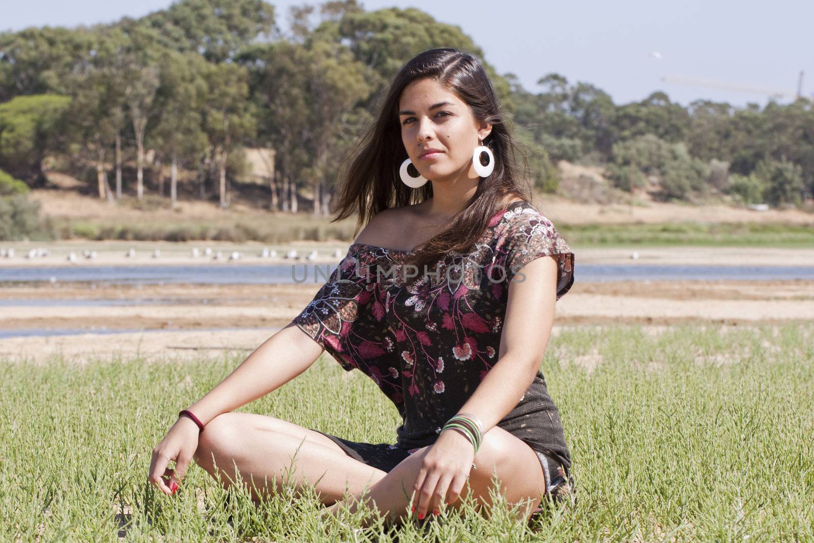 Beautiful girl with floral dress meditating on the nature.