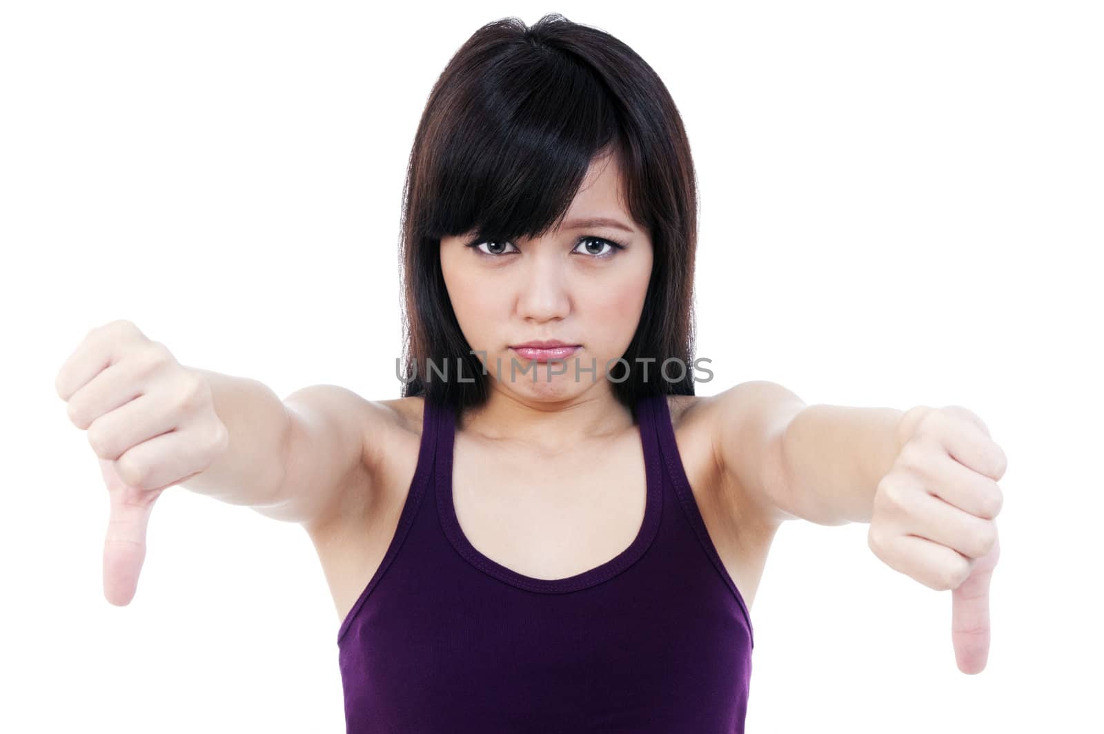 Portrait of a cute young woman showing thumbs down gesture over white background.