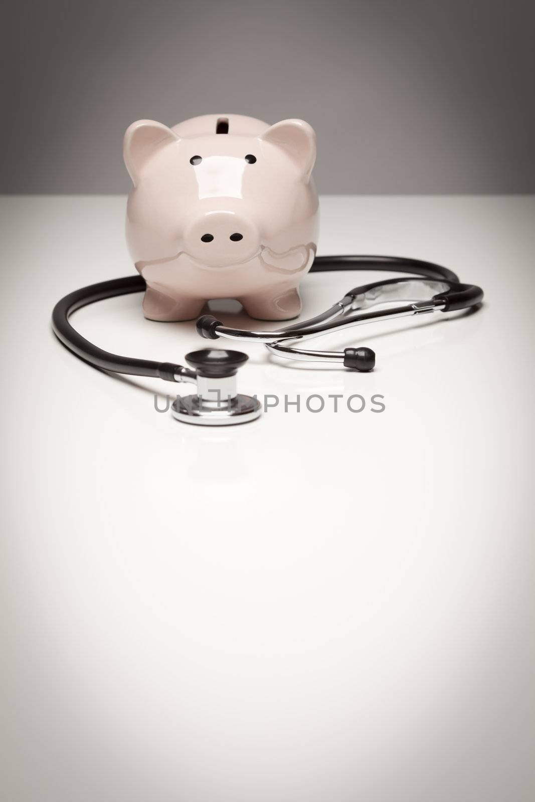 Piggy Bank and Stethoscope with Selective Focus by Feverpitched