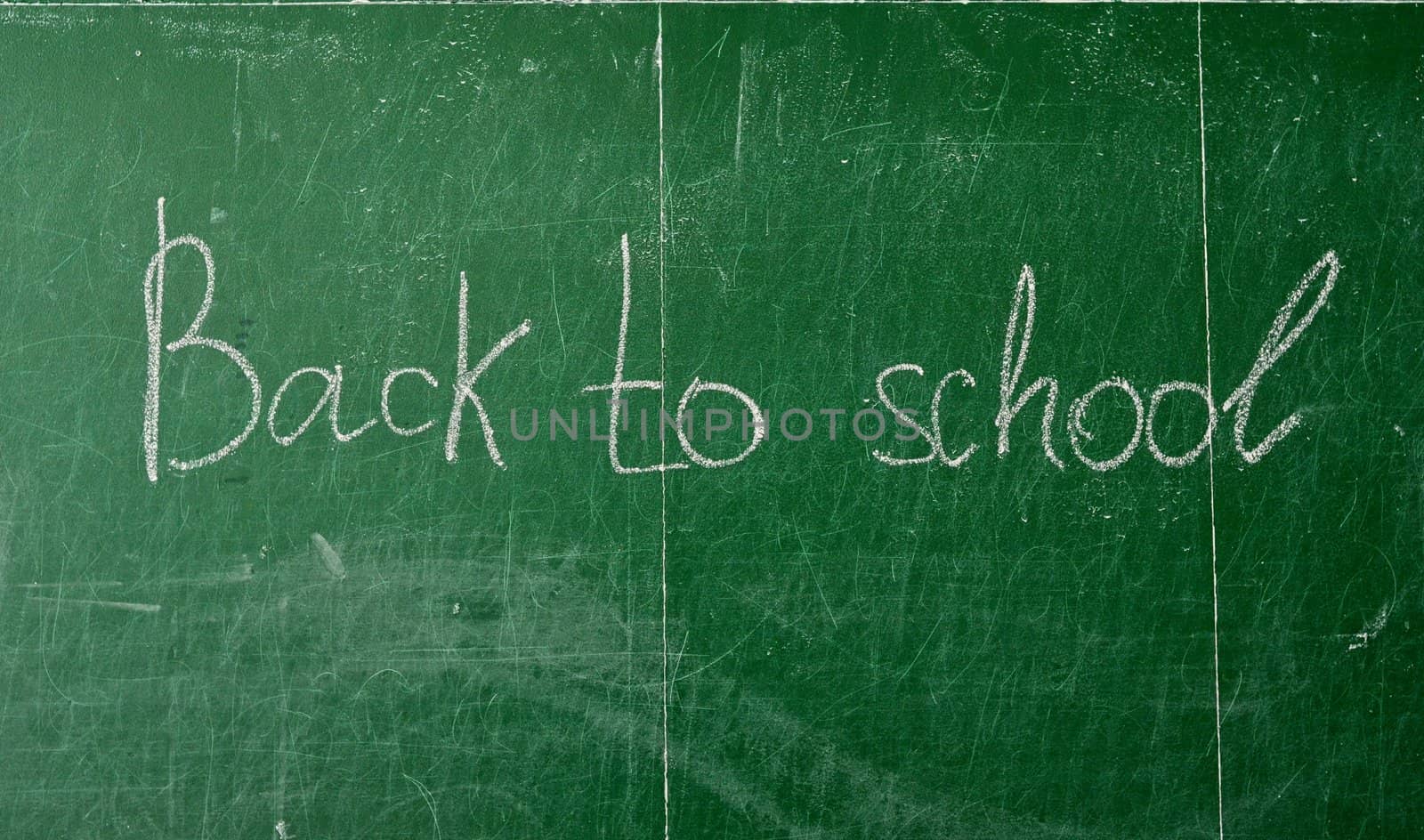 Green chalk blackboard written Back To School with white chalk