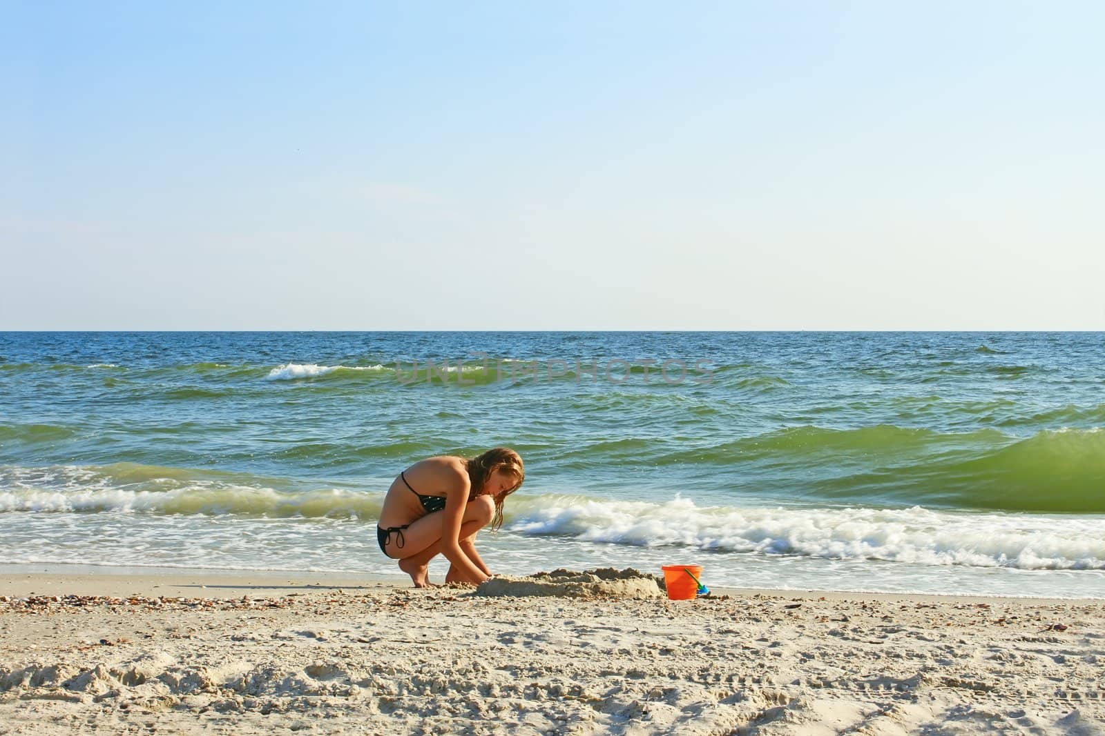 Teenage girl on an empty beach on a fine summer day
