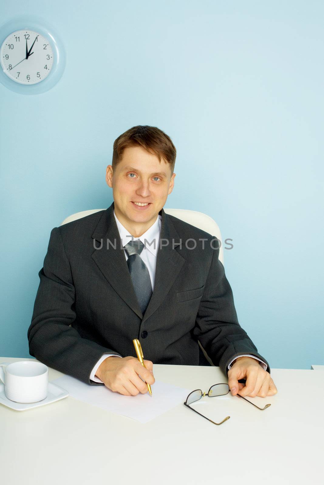Smiling business man takes notes. Office scene
