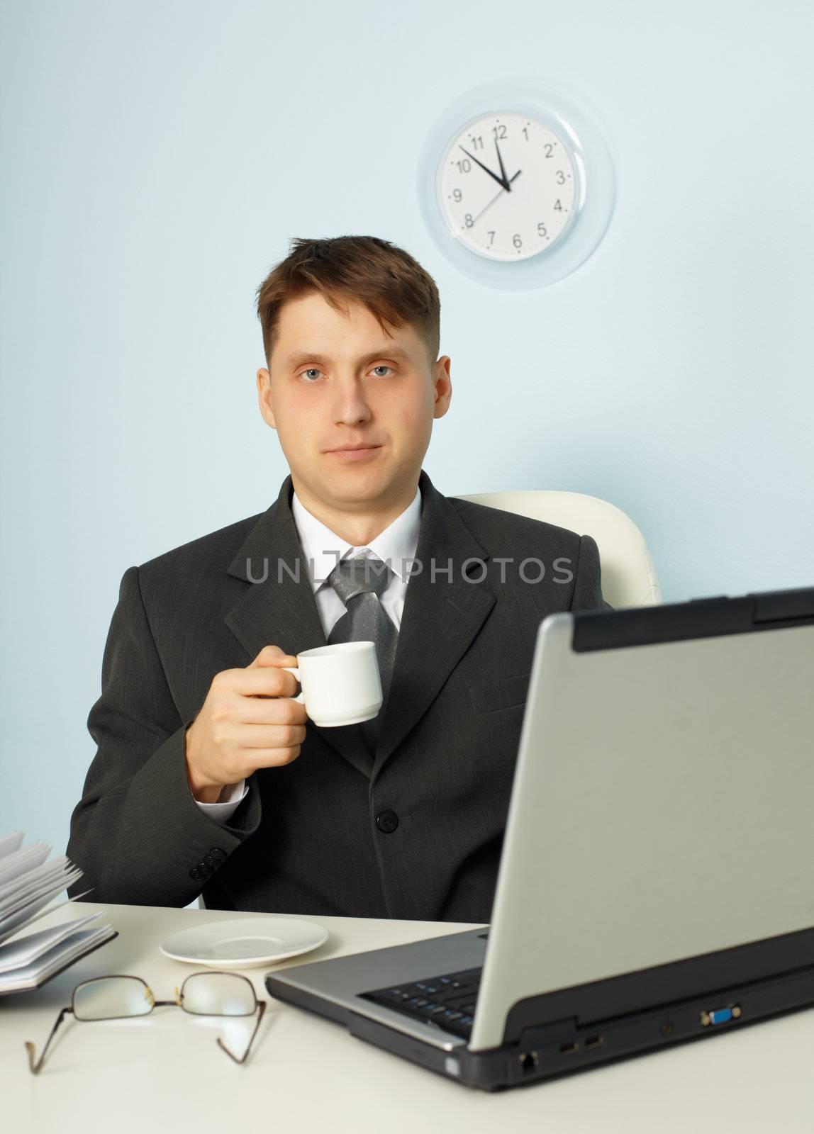 Little tired businessman drinking coffee in office by pzaxe
