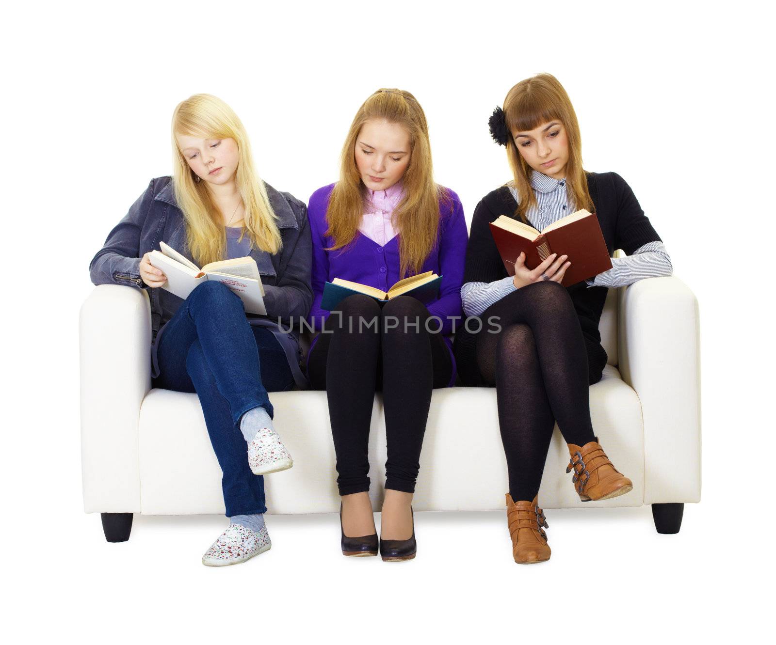 Three girls teen carefully read the books sitting on the couch. Isolated white background
