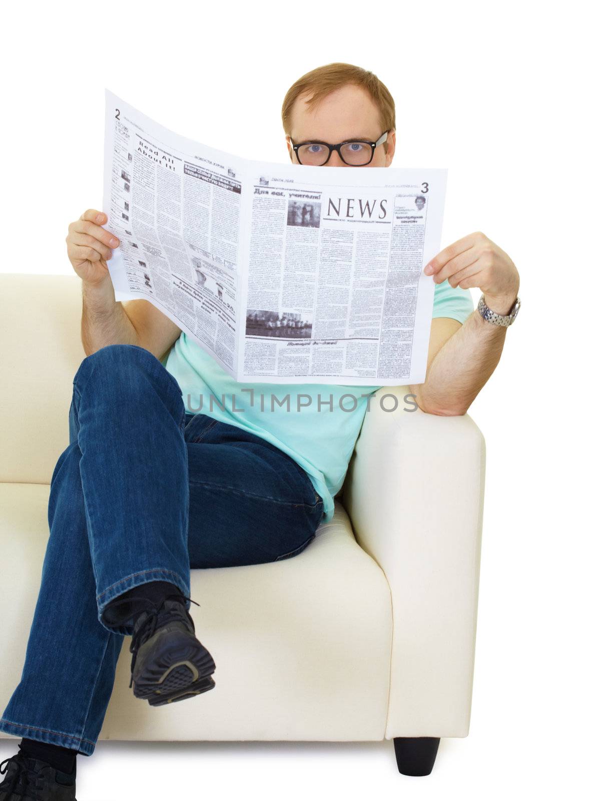 man sitting on the couch reading a newspaper. Studio photography
