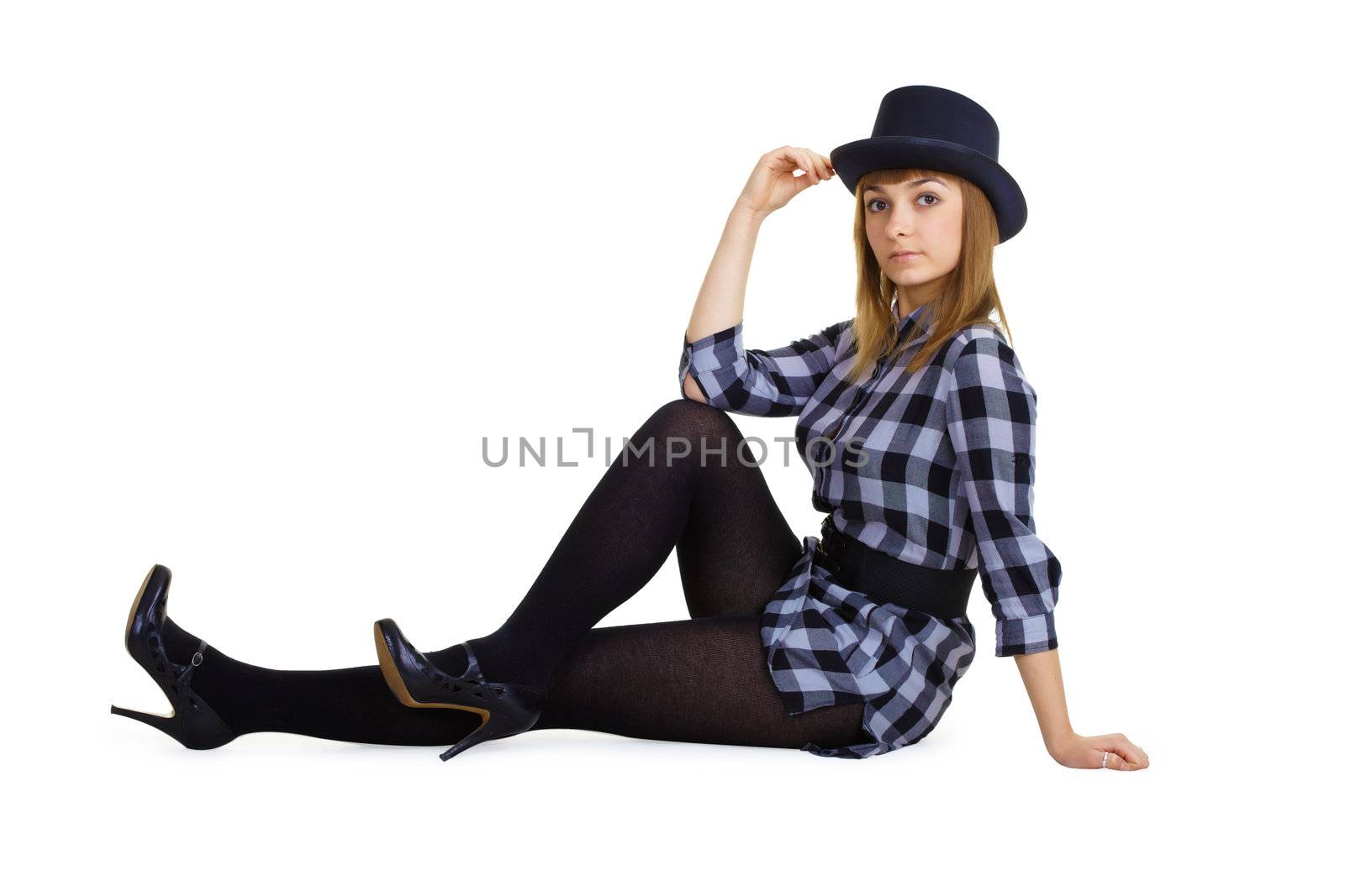 attractive girl in a hat sitting on the floor. Studio photography
