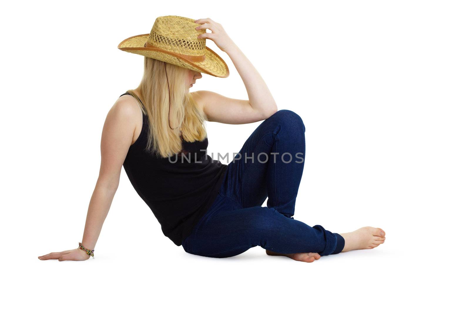 attractive girl in the wicker hat sitting on the floor on a white background
